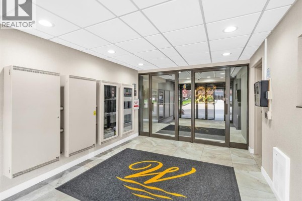 Building entrance with glass doors, grey mats, metal cabinets, and tiled floors. - 9099 Riverside Unit# 402, Windsor