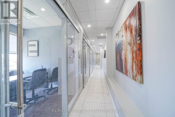 Hallway with glass-walled offices and abstract artwork on the wall. - 90uab - 7393 Markham Road, Markham
