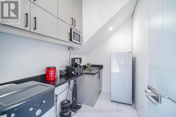 Small office kitchen with grey cabinets, a microwave, coffee maker, and refrigerator. - 90uab - 7393 Markham Road, Markham