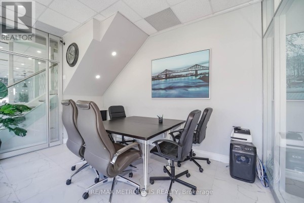 Conference room with a dark table, leather chairs, and framed bridge artwork. - 90uab - 7393 Markham Road, Markham