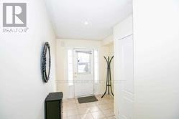 Interior entryway with tile floor, coat rack, and a black accent table. - 91 - 6399 Spinnaker Circle, Mississauga