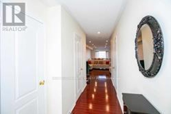 Long hallway with dark wood floor, cream walls, and an ornate mirror. - 91 - 6399 Spinnaker Circle, Mississauga