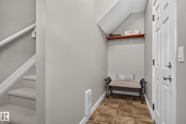 Interior foyer with gray walls, tiled floor, and a bench next to stairs. - #91 7293 South Terwillegar Dr Nw, Edmonton