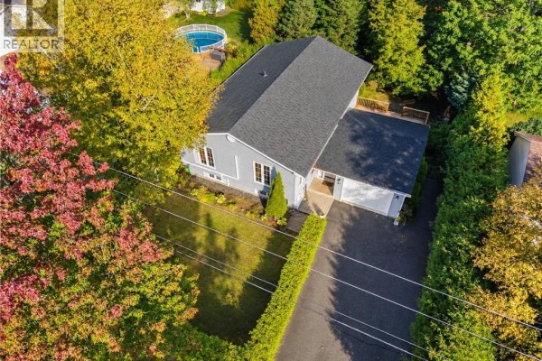 Aerial view of a grey split-level house with a dark asphalt roof, green lawn, and mature trees. - 91 Bailey Avenue, Fredericton