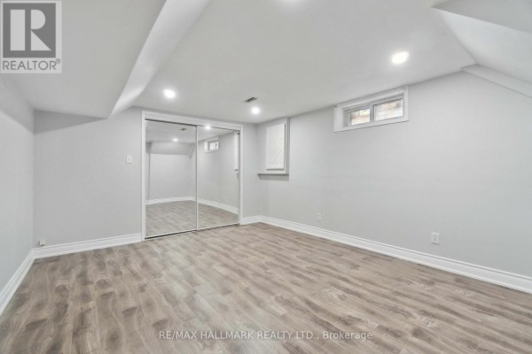 Bedroom with grey walls, wood flooring, and mirrored closet doors. - 91 Boston (lower) Crescent, Hamilton