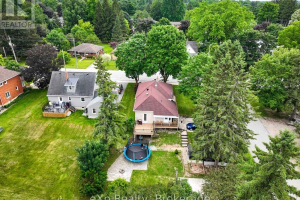 Aerial view of the property showing the back of the house, a wooden deck, and a trampoline in the yard. - 91 Charles Street, North Huron