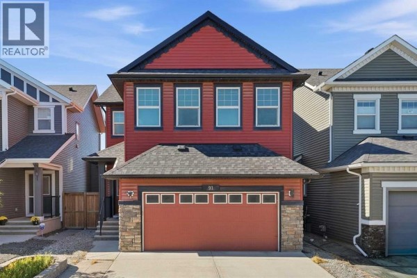 Close-up of the front porch with a red door and beige siding. - 91 Evansfield Rise Nw, Calgary