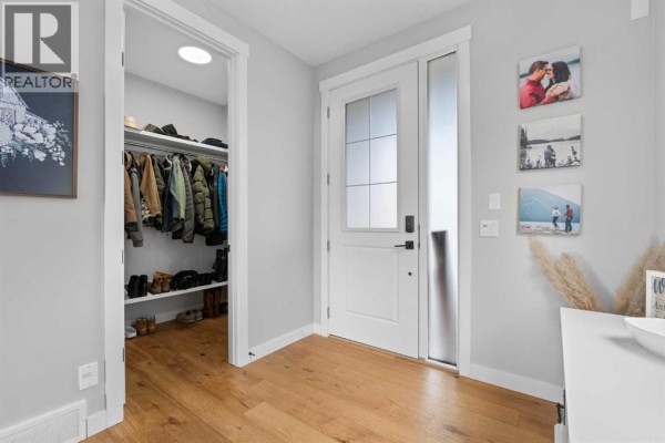 Entryway with a glass-paneled front door, a closet filled with coats, and decorative cabinetry. - 91 North Bridges Road, Langdon