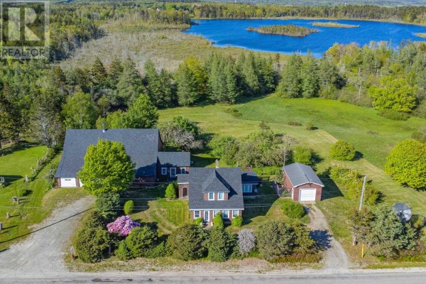 Dining room with a large wooden table, chairs, and wood-paneled walls overlooking windows and a television. - 91 Townshipline Road, Weymouth