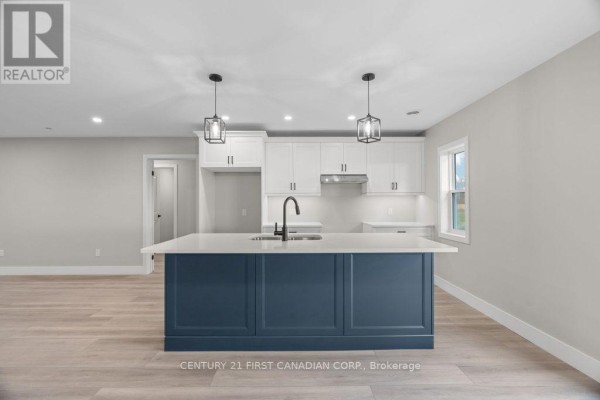 Modern kitchen with blue island, white counters and cabinets - 91 Victoria Avenue E South Huron
