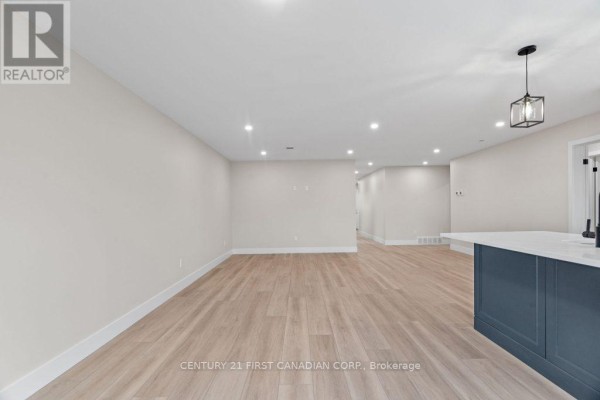 Open concept living room with kitchen island and pendant light - 91 Victoria Avenue E South Huron
