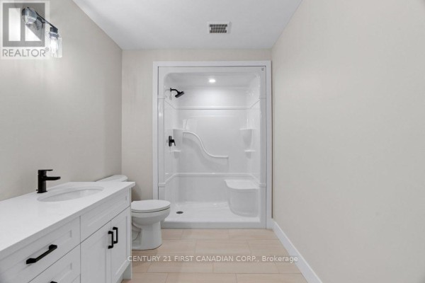 Modern bathroom with double vanity, white shower stall, and tile floors - 91 Victoria Avenue E South Huron