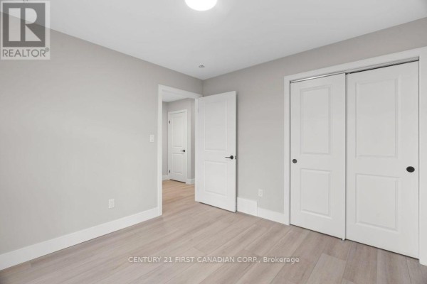 Bedroom with sliding closet doors and light wood floors - 91 Victoria Avenue E South Huron