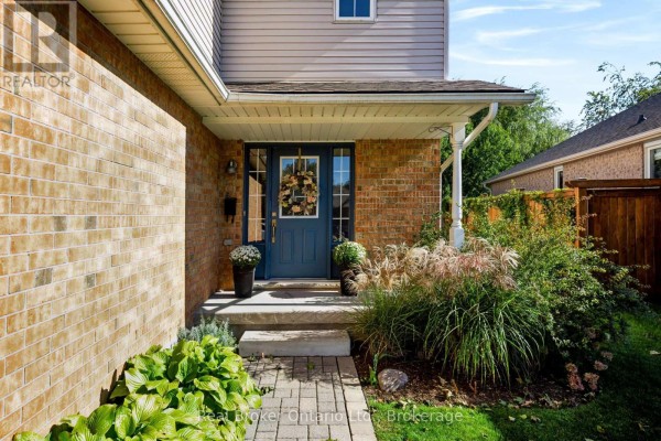 Close-up of the front door entrance with a blue door, sidelights, wreath, and surrounding brickwork. - 91 York Street E, Centre Wellington