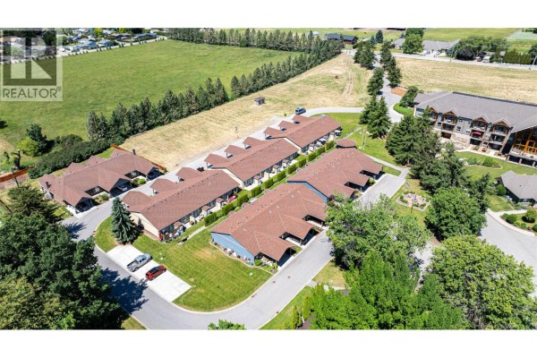 Aerial view of multiple townhouse buildings and surrounding landscaping. - 9108 Mackie Drive Lot# 1, Coldstream