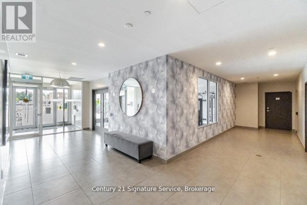 Lobby area with tile flooring, seating, and decorative wall - 911 - 716 Main Street E, Milton