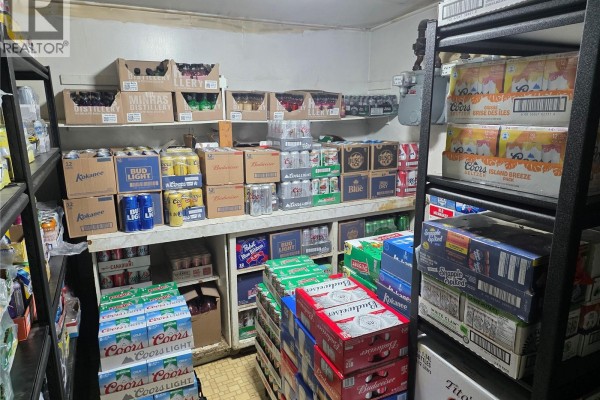 Stock room with shelves filled with cases of beer and bottles of liquor. - 911 18 Highway, Carnduff