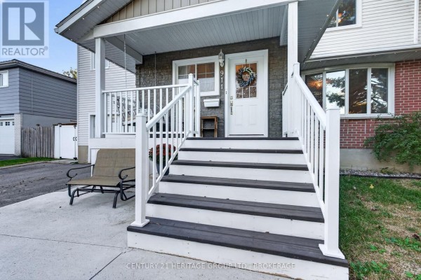 Front porch with white railings, dark wood steps, and a grey bench. - 911 Auden Park Drive, Kingston