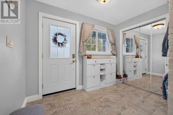 Foyer with doors, white storage unit, window with curtains, and mirrored closet doors. - 911 Auden Park Drive, Kingston