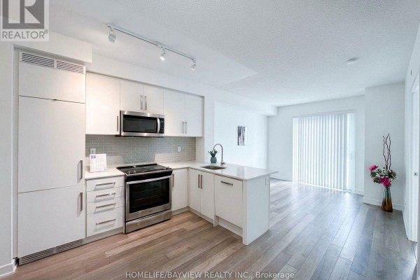 Open-concept living area with light-colored walls and modern kitchen - 912 - 5180 Yonge Street, Toronto