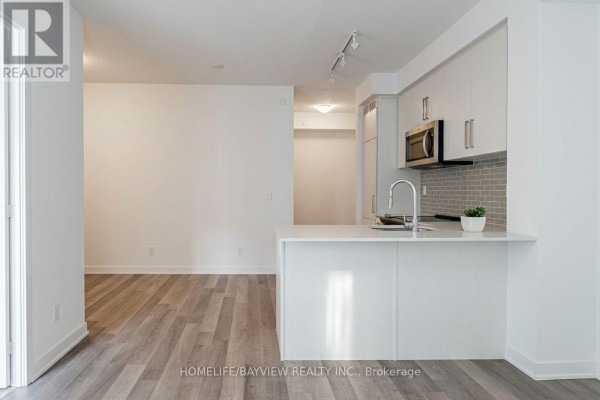 Modern kitchen featuring stainless steel appliances and light green backsplash - 912 - 5180 Yonge Street, Toronto