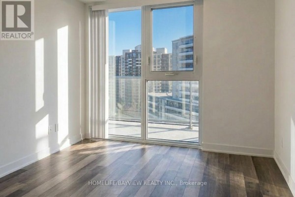 Empty room with light walls and hardwood flooring, ready for customization - 912 - 5180 Yonge Street, Toronto