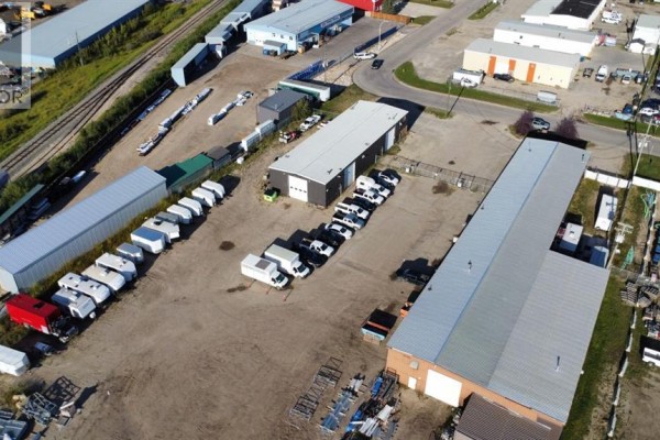 Aerial view of industrial park with buildings, vehicles, and railway tracks. - 9124 111 Street, Grande Prairie
