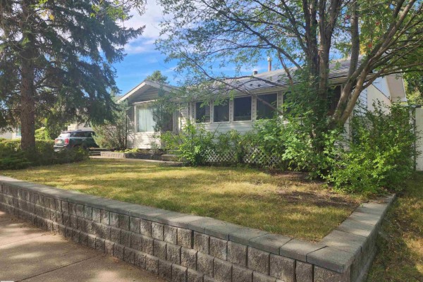 Front view of a house with a gray exterior, white trim, and windows along the front and side. - 9126 92 Av, Fort Saskatchewan