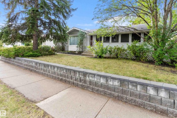 Street view of a residential neighborhood with houses on either side, mature trees, and parked cars. - 9126 92 Av, Fort Saskatchewan