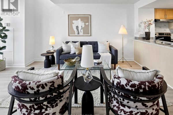 Living room facing a navy sofa and two patterned armchairs. - 913 - 77 Lombard Street, Toronto