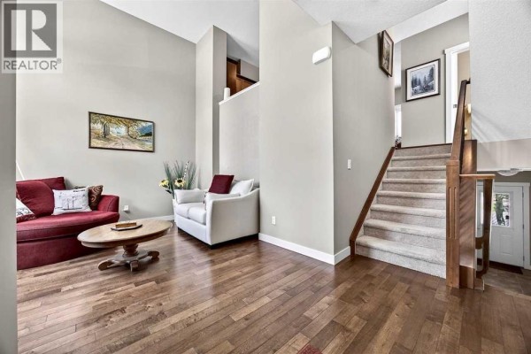 Close-up of the townhouse entrance with white columns, a wooden door, and windows. - 913 Evanston Square Nw, Calgary
