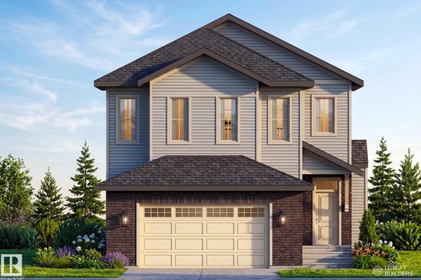 A two-story modern home with light blue siding and brick, illuminated at dusk with interior lights visible through the windows. - 9138 104 St, Morinville