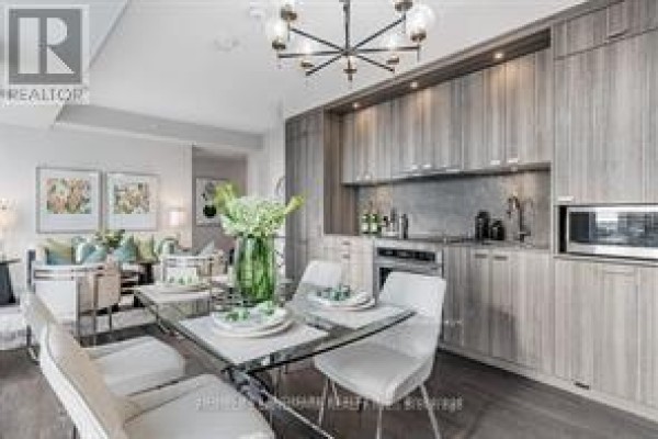 Open-concept living space with kitchen, dining area, and stylish lighting fixture - 914 - 480 Front Street W, Toronto