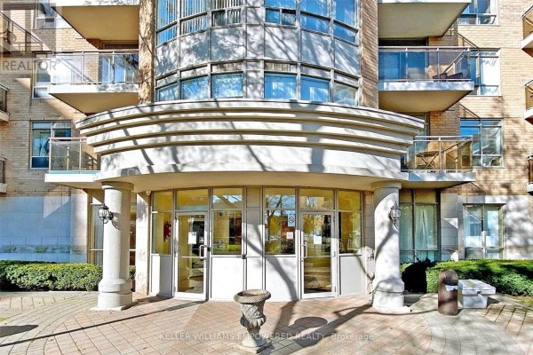 Close-up of the building entrance with columns, glass doors, and paved walkway. - 915 - 650 Lawrence Avenue W, Toronto