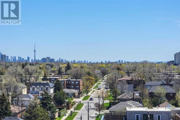 Panoramic city view from a balcony with buildings and trees in the foreground. - 915 - 650 Lawrence Avenue W, Toronto