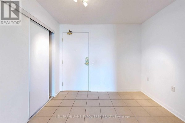 Interior view of an empty apartment hallway with tiled floor and white walls. - 915 - 650 Lawrence Avenue W, Toronto