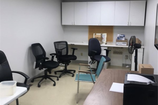 Office area with desks, chairs, filing cabinets, and a printer. - 916 Central Avenue, Saskatoon