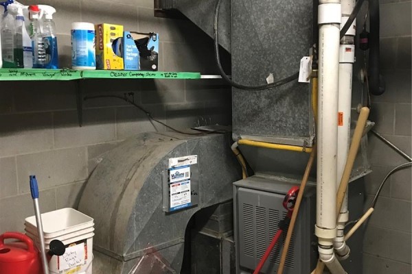 Mechanical room with furnace, ventilation ducts, and cleaning supplies on a shelf. - 916 Central Avenue, Saskatoon