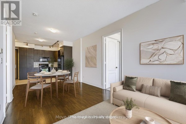Open concept living and dining area with a kitchen view and hardwood floors. - 917 - 50 Clegg Road, Markham
