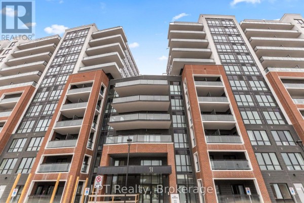Low-angle view of the apartment building entrance with balconies and windows. - 917 - 51 Clarington Boulevard, Clarington