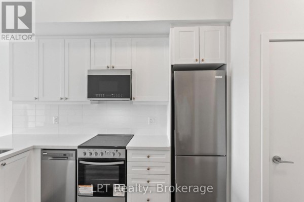 Close-up of a modern white kitchen with stainless steel appliances and white cabinets. - 917 - 51 Clarington Boulevard, Clarington
