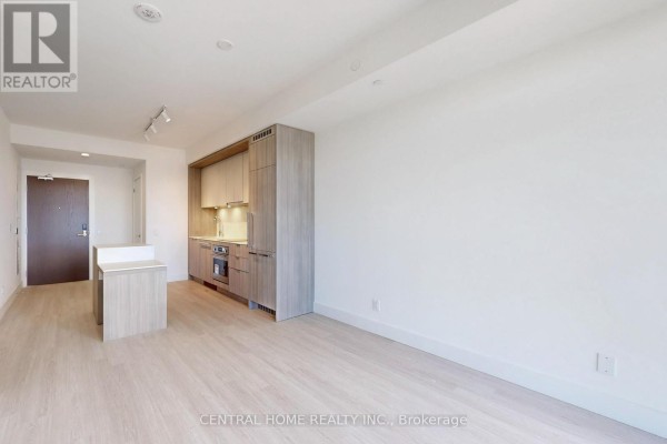 Open concept living and kitchen area with light wood floors, white walls, and a modern kitchen. - 917 - 6 Greenbriar Road, Toronto