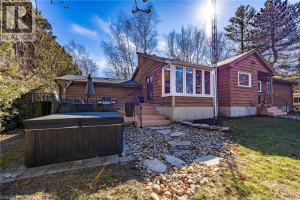 Side view of the house with a hot tub and stone pathway - 917 Concession Rd 6, Waterford