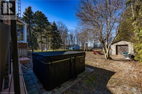 Hot tub area with trees and a shed in the background - 917 Concession Rd 6, Waterford