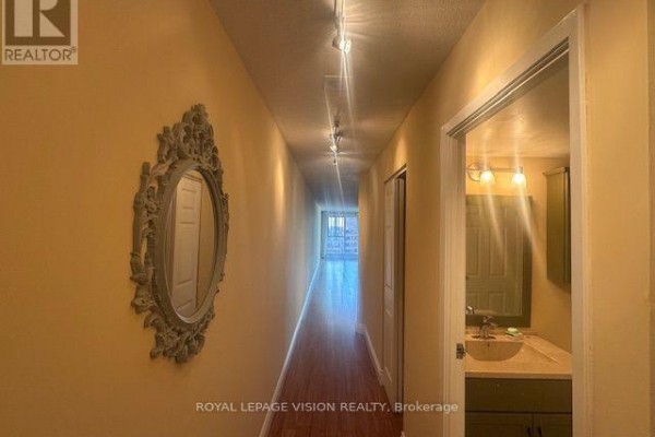 Interior hallway with yellow walls, a decorative mirror, track lighting, and a doorway to a bathroom. - 919 - 222 The Esplanade Street, Toronto
