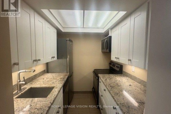 Compact kitchen with white cabinets, granite countertops, a stainless steel sink, dishwasher, and stove. - 919 - 222 The Esplanade Street, Toronto