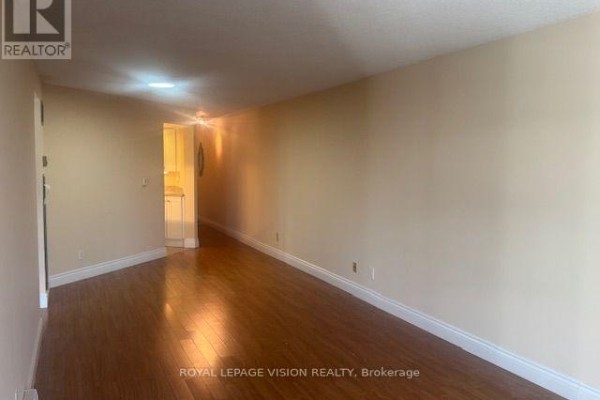 Empty living space with hardwood floors, beige walls, and a view into a hallway. - 919 - 222 The Esplanade Street, Toronto
