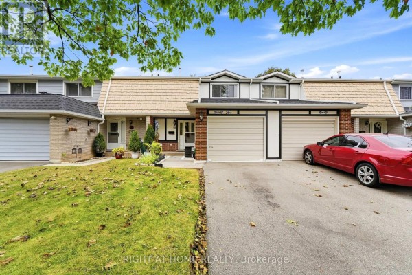 Street view of a townhouse complex with red car in driveway and green lawn. - 92 - 92 St Andrews Drive, Hamilton
