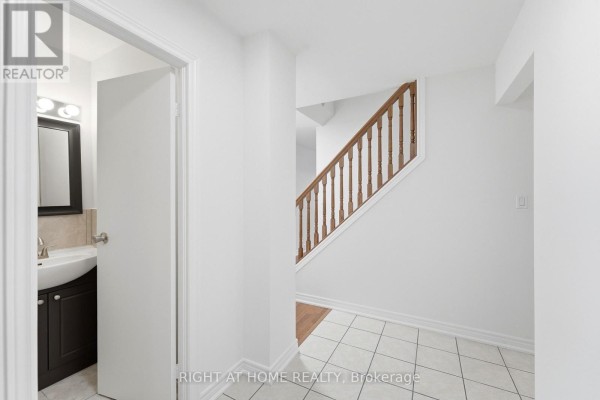 Hallway interior with white walls, tiled floor, and wooden staircase with railing. - 92 - 92 St Andrews Drive, Hamilton