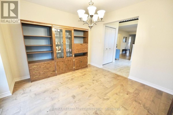 Dining room with wood floors, a large built-in bookcase, and a doorway to the hallway. - 92 Aberdeen Street, Centre Wellington